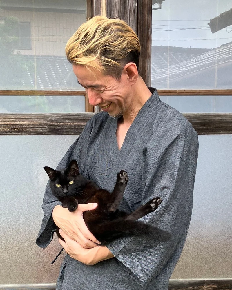 猫を抱いて笑顔を見せる担当エンジニア
